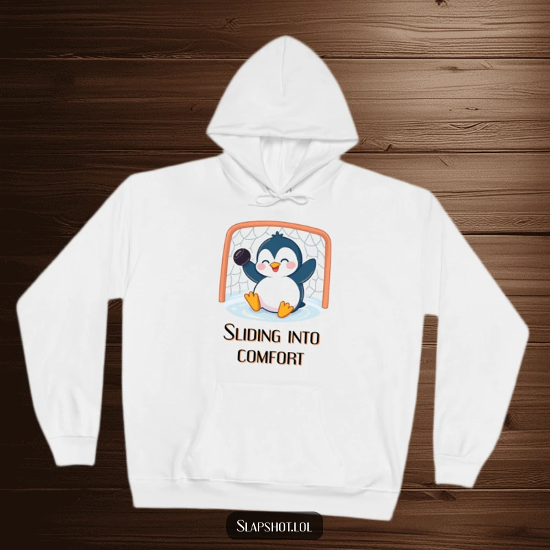 Funny penguin hoodie depicting a giggling character sliding into a net with a puck, offering warmth and humor.