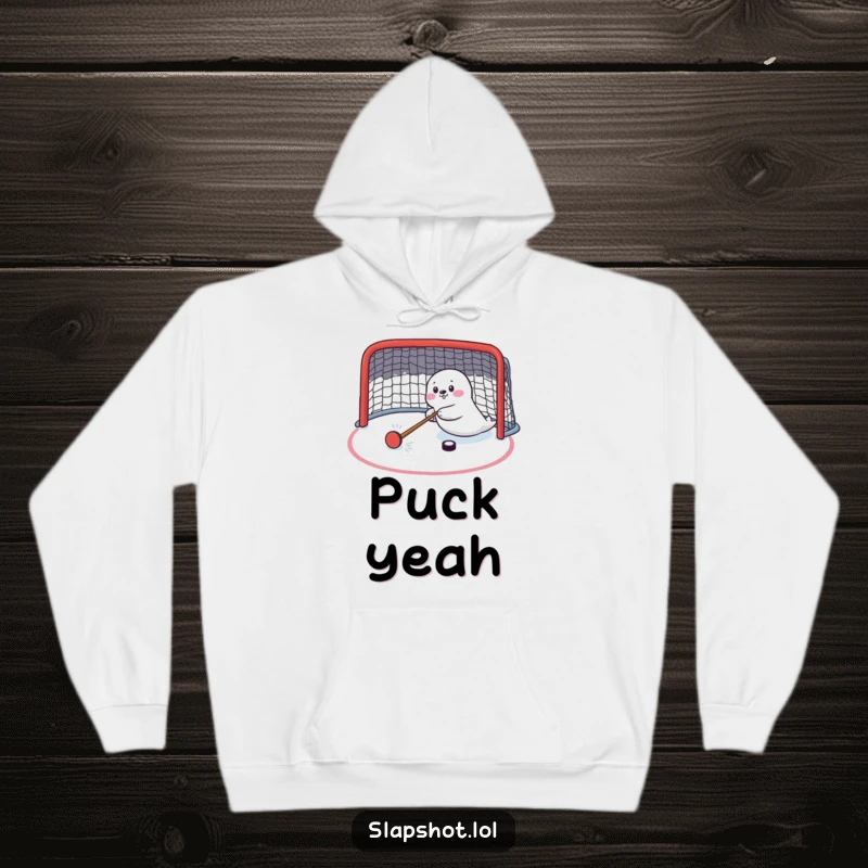Funny seal character comically shooting a hockey puck, featured on a warm hoodie, a humorous sports apparel.