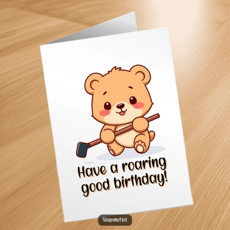 Funny Free Printable Birthday Card showing a happy bear cub with a miniature hockey stick playfully batting a puck.