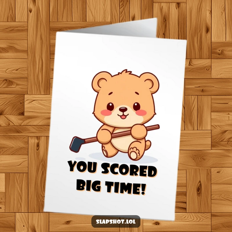 Funny Free Printable Congratulations Card featuring a happy bear cub with a small hockey stick, playfully batting a puck.
