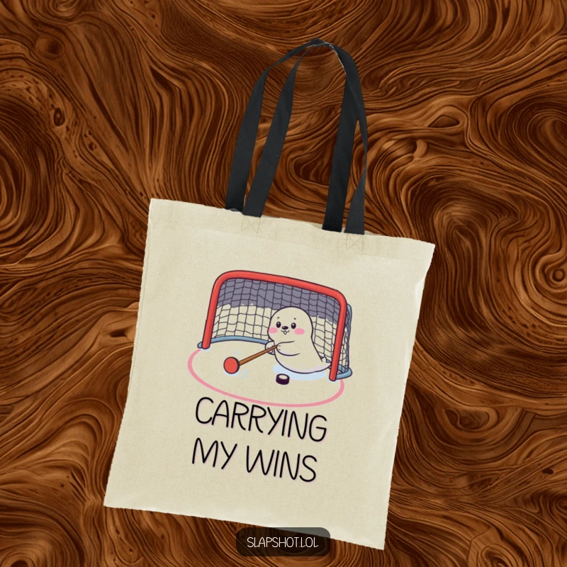 Funny seal character on a tote bag, enthusiastically shooting a hockey puck, perfect for sports and humor lovers.