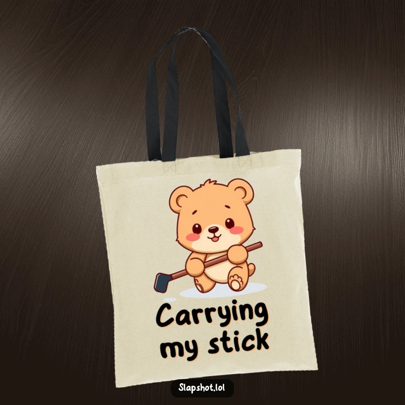 Funny tote bag with a happy bear cub holding a tiny hockey stick, playfully batting a puck, perfect for carrying sports essentials.